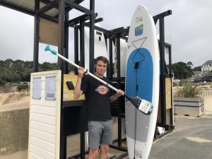 Playa-Rent founder Nicolas Roche with his first paddleboard rental station on La Noëveillard beach. (Image: Ouest-France.)